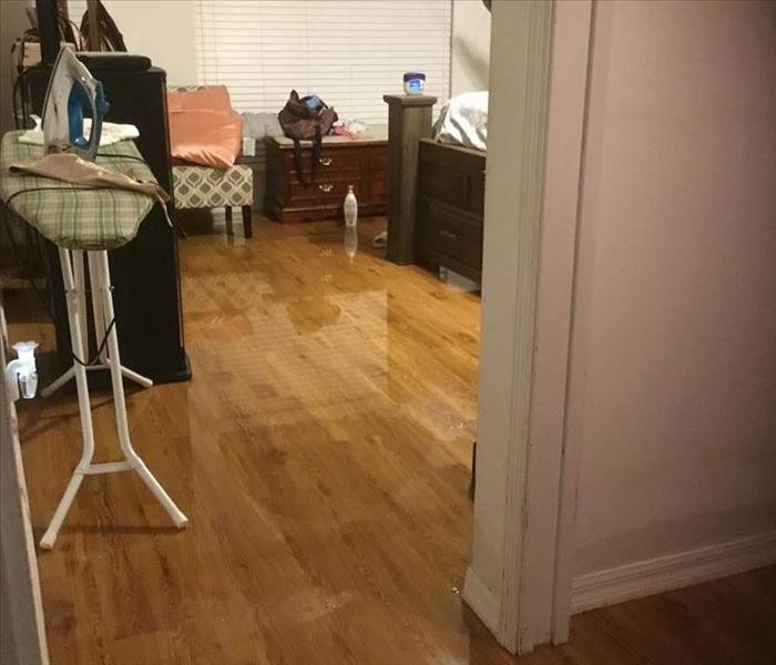 Bedroom with furniture and water on floor - can see the reflection