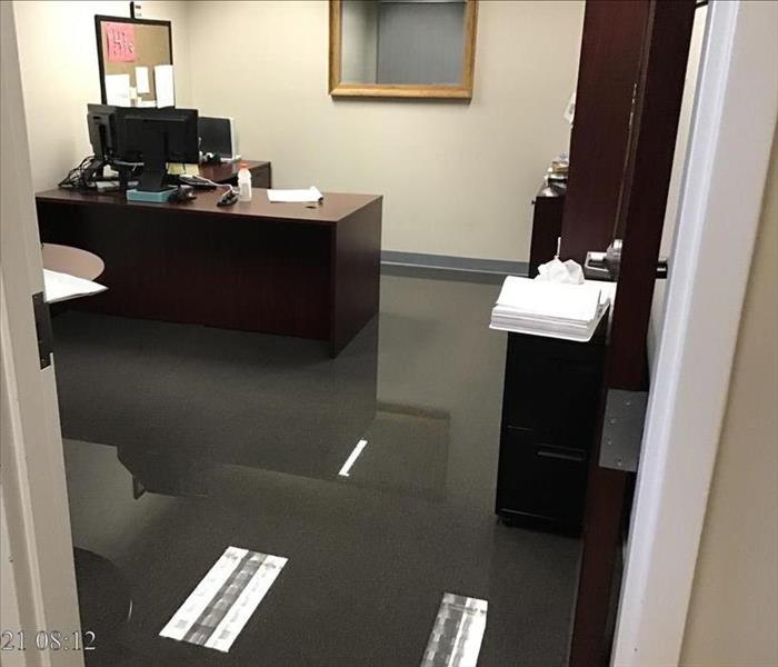 Office with furniture including a desk with a few inches of standing water on it